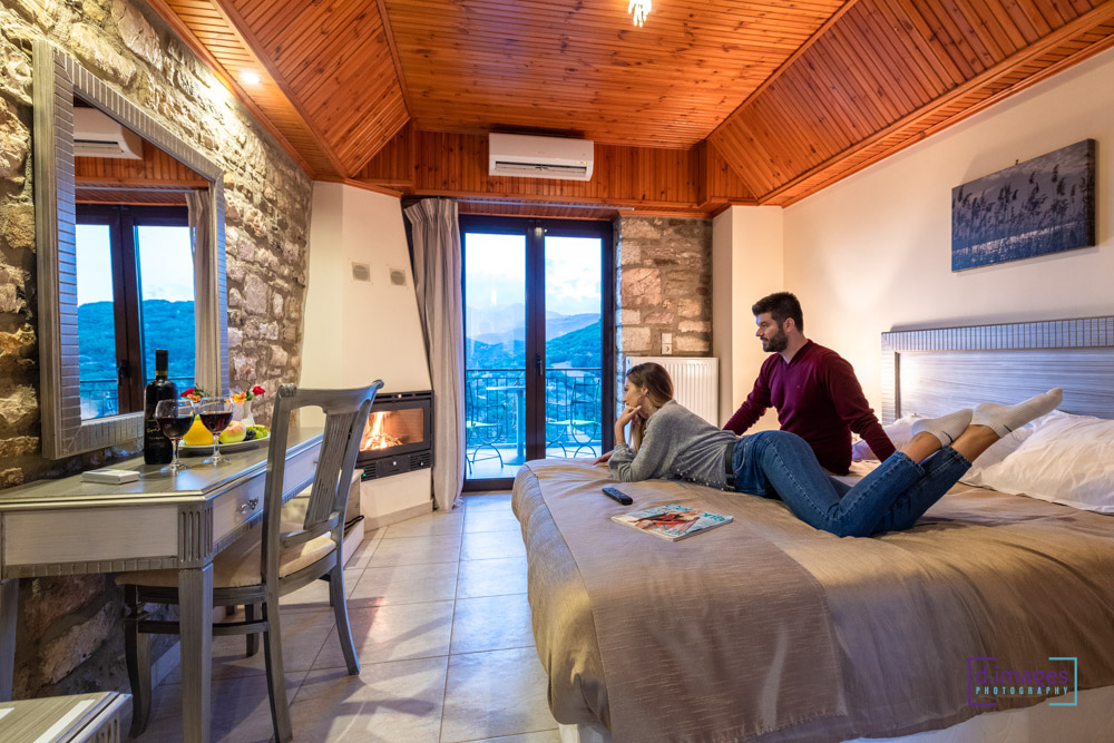 φωτογράφιση ξενοδοχείου, ζευγάρι στο κρεβάτι με θέα στο τζάκι